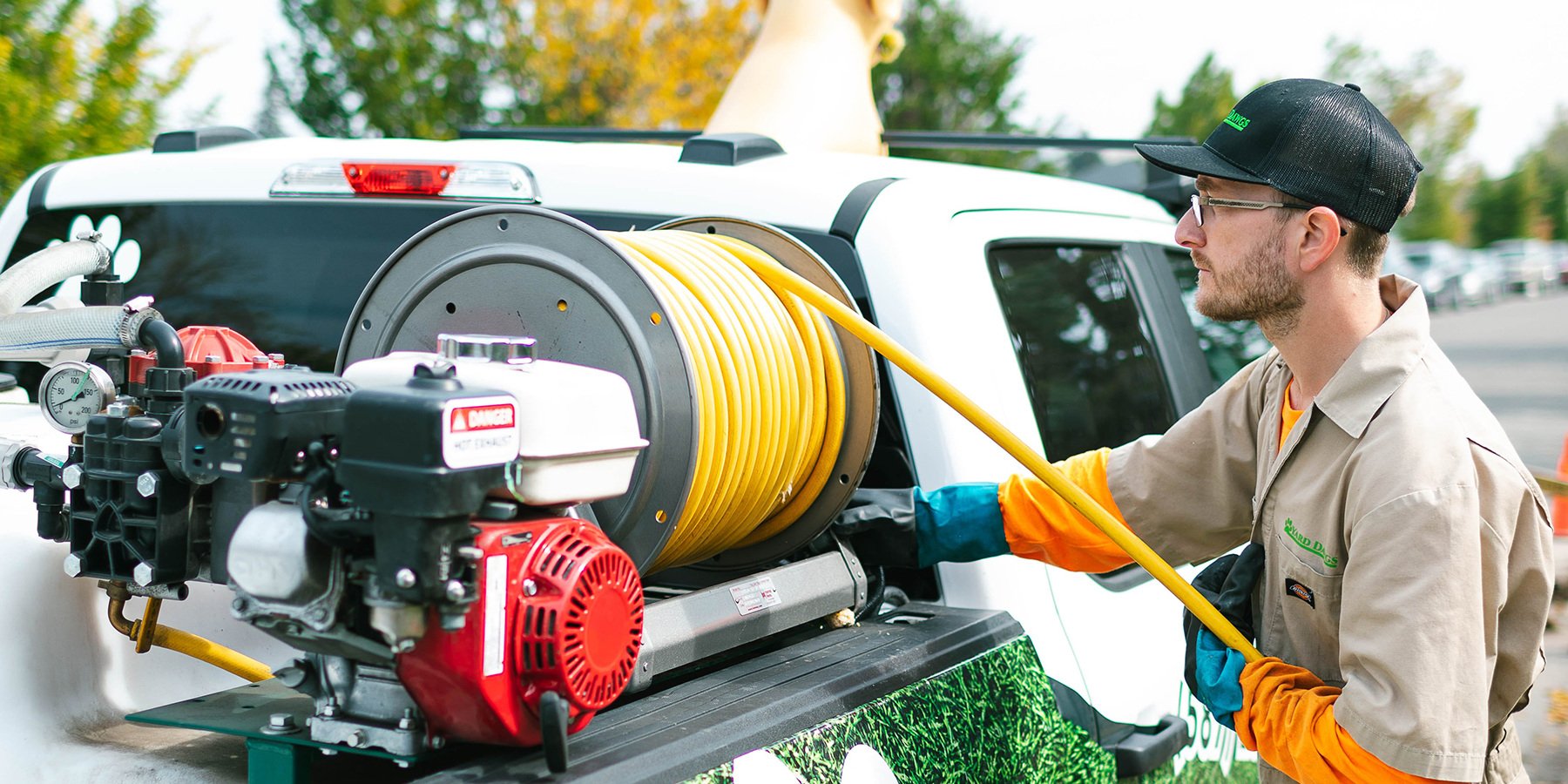 Lawn Specialist Unloading Hose From Truck
        style=